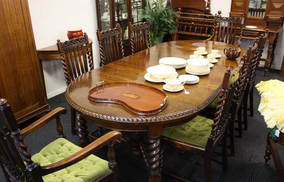A restored antique extending dining table with carved edge, set for dinner