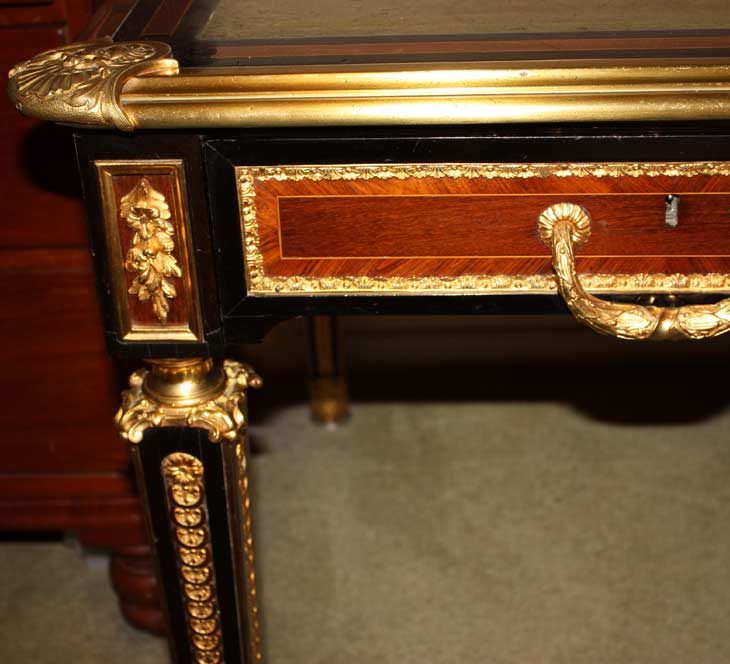 Corner of a bureau plat with gilt ormolu mounts and a crossbanded drawer